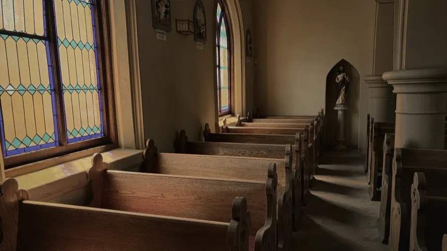 Pews beside a stained-glass window at St. James Church