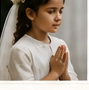 A child prepared for First Communion in prayer.
